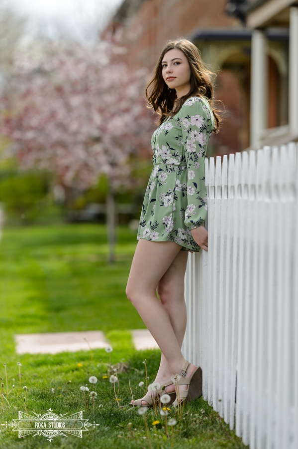 Denver senior girl alongside white picket fence. 
