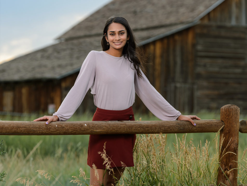 Senior photo in front of rustic barn
